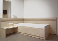 Einzelbett mit einem Wandpaneel in einer Rehaklinik